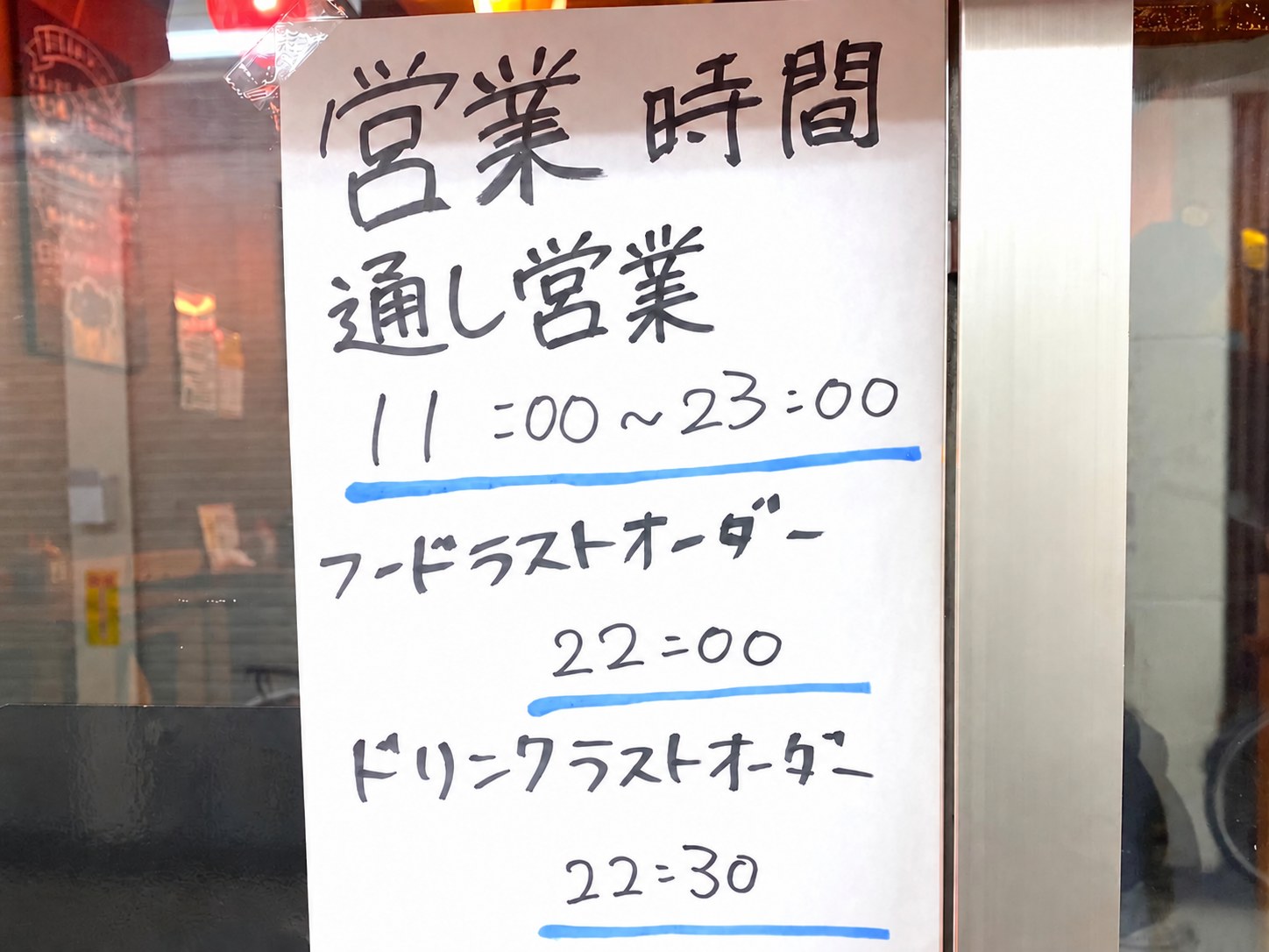 A sign at an izakaya entrance showing opening hours, open all day