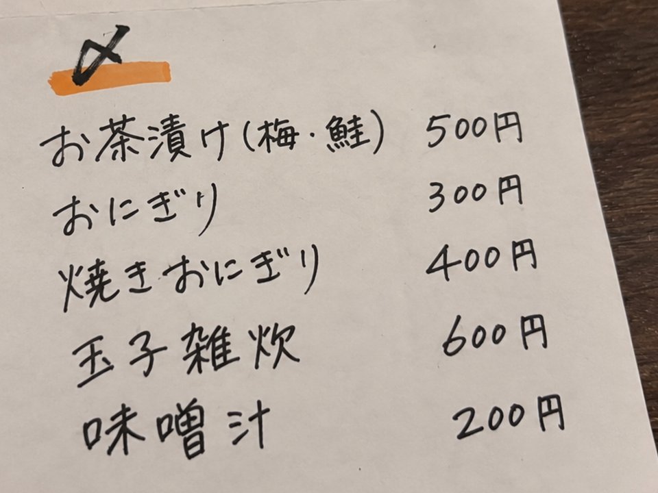 A handwritten izakaya menu with a section headed 〆 listing ochazuke, onigiri and zosui